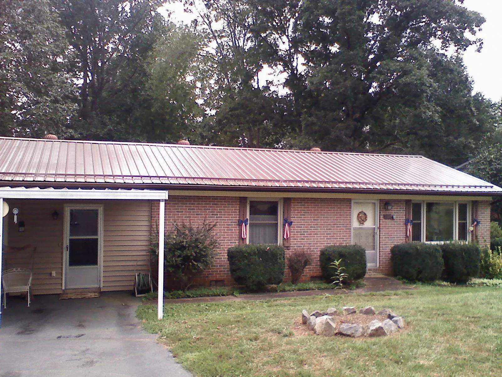 Bronze metal roof and carport on a brick ranch home — Roof Repair work by our crew in Sunnyside